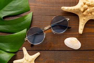 Blue sunglasses on wooden background, top view