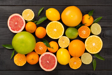 Different citrus fruits on wooden background, top view