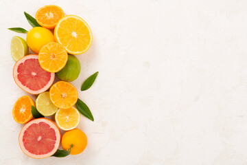 Different citrus fruits on concrete background, top view