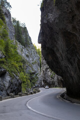 winding road with a car passing through the impressive Bicaz Canyon, a beautiful and majestic gorge...