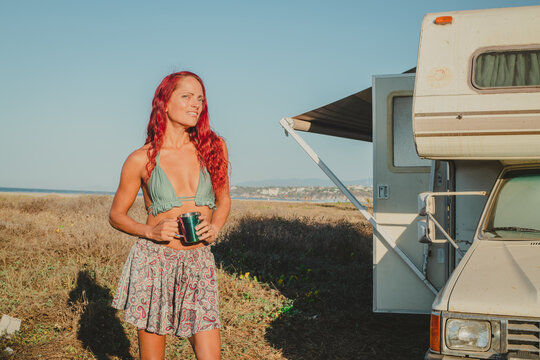 young woman with an RV on the beach