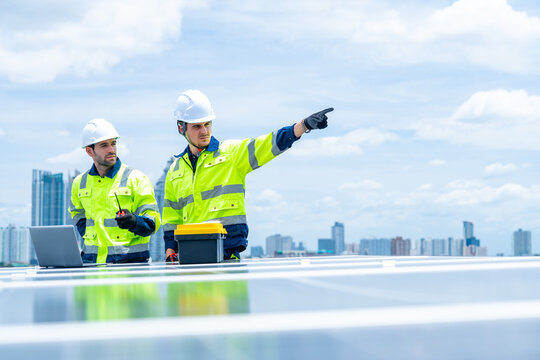 Solar cell, electricity alternative renewable clean energy for environmental conservation, sustainability technology. Male engineer maintaining solar panel system on construction site building rooftop