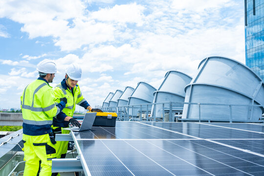 Solar cell, electricity alternative renewable clean energy for environmental conservation, sustainability technology. Male engineer maintaining solar panel system on construction site building rooftop