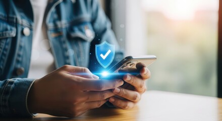 Person holding a smartphone with a glowing digital shield and checkmark symbolizing data protection and security