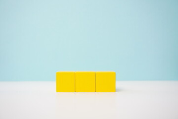 Yellow wooden blocks on a blue background, for conceptual education visuals. It can be used to explain and clarify various concepts.