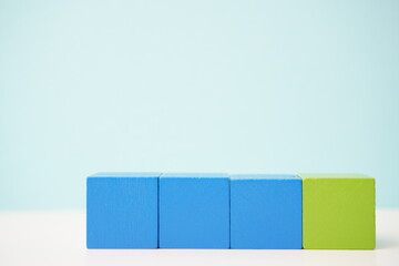 Colorful blue and green wooden blocks aligned on a light background for creative and educational use. It can be used to explain and clarify various concepts.