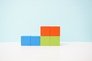 Colorful building blocks arranged against a pastel blue background. It can be used to explain and clarify various concepts.