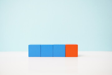 Four colorful wooden blocks in a row against a blue background representing creativity, education, and simplicity. strategy, business, economy and educational concepts