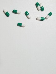 Green and white medicine capsules