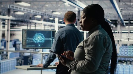 Team of data center technicians checks AI dashboard using laptop during systems review. Teamworking server hub colleagues test artificial intelligence tools on notebook, camera B - Powered by Adobe