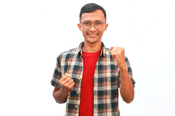 An Asian man clenches his fist with a happy expression.