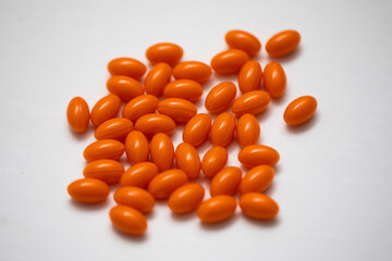 Bright orange coenzyme q10 dietary supplement pill medicine on white background in the center 