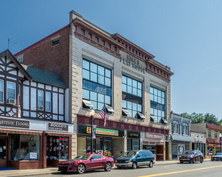 Suffern, NY - US - Aug 10, 2025 The Hines Playhouse building in Suffern, NY, now home to businesses like Fern Supermarket, a law office, and Licata Insurance, on a sunny day