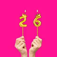 Birthday on a fuchsia background with the number 26 - Hands holding number-shaped candles