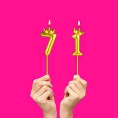 Hands holding number shaped candles - Birthday number 71