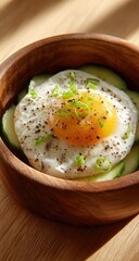 Sunny-side-up egg with a runny yolk, nestled on thinly sliced cucumbers in a rustic wooden bowl, seasoned with pepper and chives