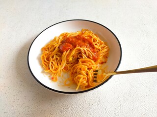 A beautifully plated dish of spaghetti with a rich, savory tomato sauce at the center. 