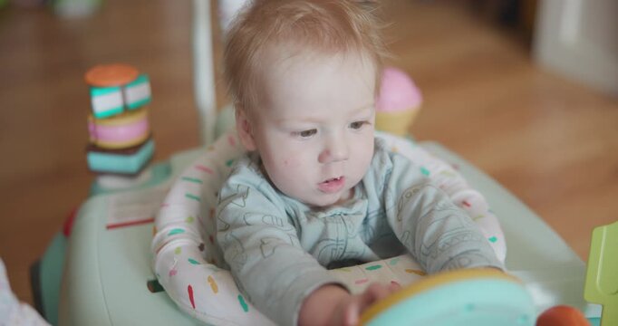Cute Red Head Baby in Bouncer With Messy Hair