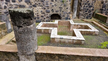 Herculaneum, Italy - 9 January 2025. Central courtyard with a marble-edged cross-shaped basin,...