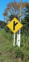 Gelbes Rautenschild in Brasilien mit Abfahrthinweis – geradeaus und rechts abbiegen möglich