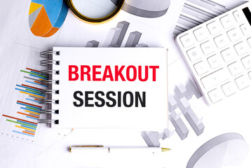 Notepad with breakout session text on desk with charts and calculator
