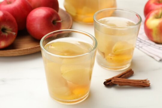 Tasty compot with apples and cinnamon on white table, closeup