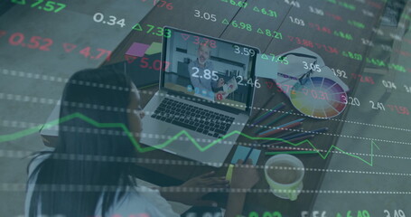 Woman reviewing smartphone at wooden desk joining colleague on laptop, color wheel and data overlay
