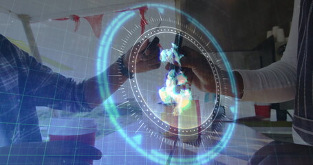 Clinking friends raising amber beer bottles over kitchen bar, with red cup, streamers, hologram