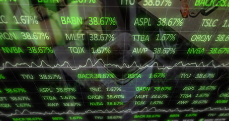 Man wearing collared shirt analyzing market data on overlay screen at desk with laptop and mug