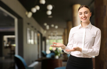 Young hostess welcoming to restaurant. Space for text