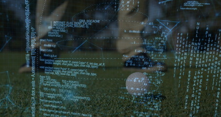 Soccer player in jersey kicking soccer ball on grass turf at stadium, with programming code overlay