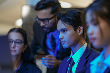 An Indian business manager leads his diverse team, analyzing critical market data on a screen. Intense focus on financial strategy and corporate decision making in a modern office.