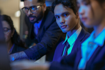 A senior AI architect mentors a diverse team as they debug a complex neural network. Intense,...
