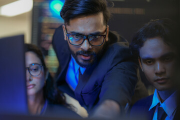 A senior AI architect mentors a diverse team as they debug a complex neural network. Intense,...