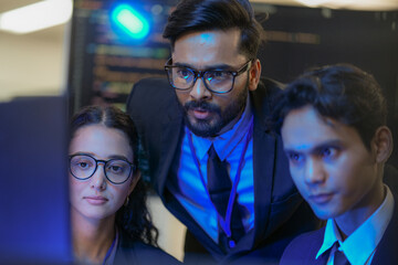 A senior AI architect mentors a diverse team as they debug a complex neural network. Intense,...