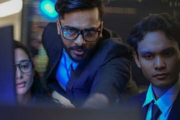 A senior AI architect mentors a diverse team as they debug a complex neural network. Intense,...