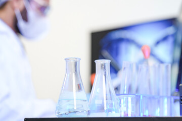 A diverse team of scientists collaborates in a high-tech biotech lab. A senior researcher mentors...