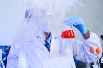 A focused scientist in full protective gear meticulously compares two different chemical solutions...