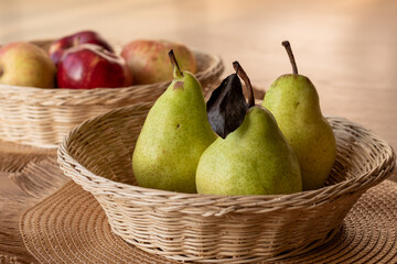 Fresh Pears in a Wicker Basket with Apples in the Background