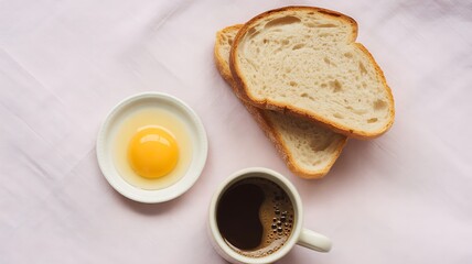 Top down view of breakfast with raw egg, bread slices, and coffee egg yolk toast