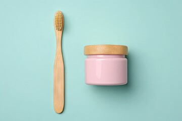 Light teal background, bamboo toothbrush, and pink container