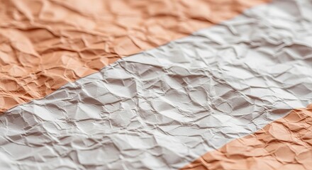 Close up of crumpled paper with diagonal color split in peach and white creating a textured backdrop