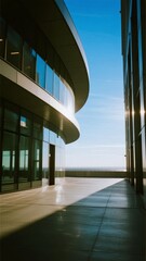 Fototapeta premium Modern Curved Building with Glass Facade and Reflective Shadows