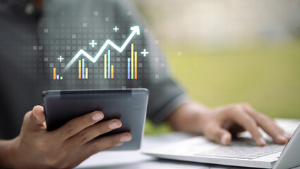 Business growth analytics on tablet and laptop with upward graph chart