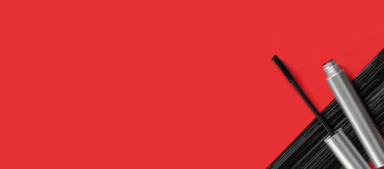 Black mascara in silver tube with sample on red background