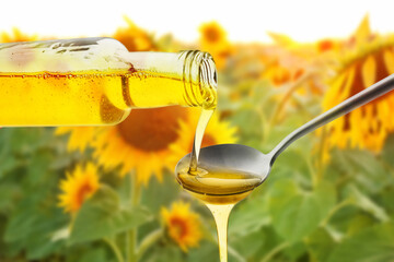 Pouring of fresh olive oil from bottle into spoon on white background