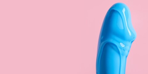 Vibrator covered with lubricant on pink background with space for text, closeup