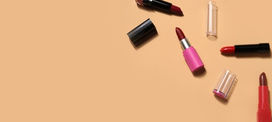 Obraz premium Different lipsticks on beige background with space for text, top view