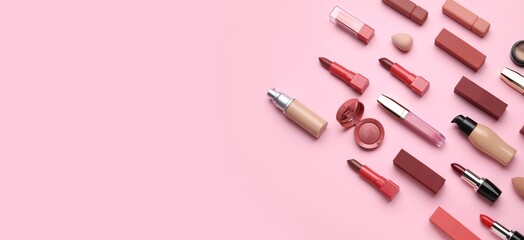 Many lipsticks and decorative cosmetics on pink background with space for text, top view
