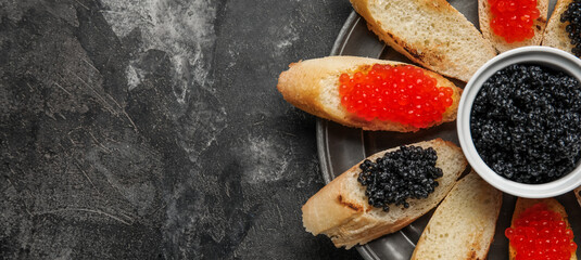 Tasty bruschettas with red and black caviar on dark grunge background